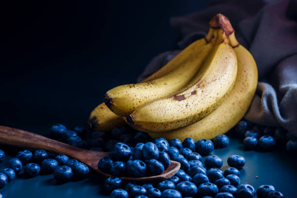 banana Fresh Blueberries blueberry Bowl Table Freshly picked glass bowl. Juicy fresh blueberries Bilberry dark food Background. antioxidant. Concept healthy eating nutrition fruit smoothie Healthy