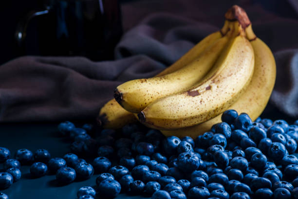 banana Fresh Blueberries blueberry Bowl Table Freshly picked glass bowl. Juicy fresh blueberries Bilberry dark food Background. antioxidant. Concept healthy eating nutrition fruit smoothie Healthy