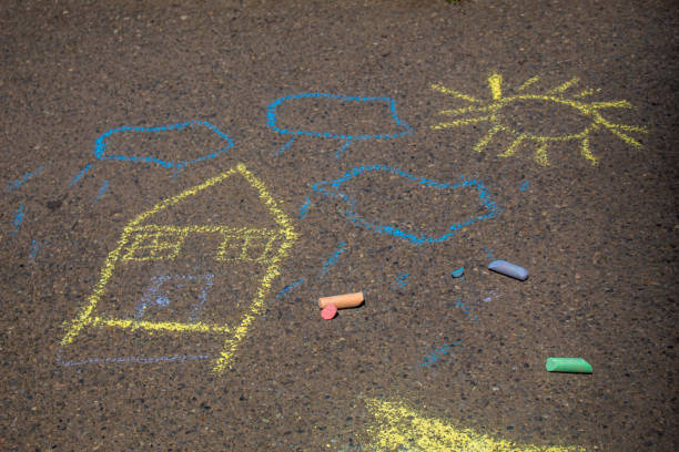 istock Children paint a rainbow on the asphalt. Selective focus. 1417861569