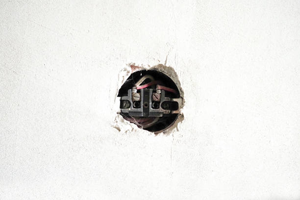 istock Old open socket. Old socket without the covering on the white concrete wall. Renovation concept 1417862319