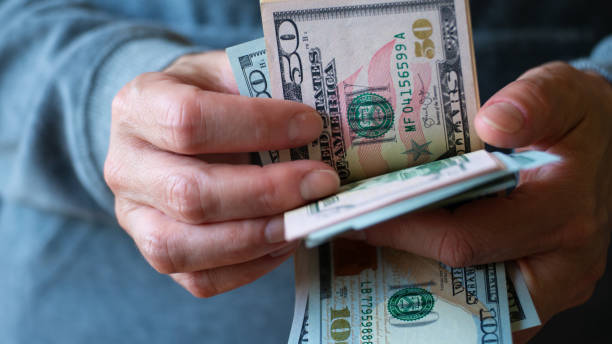 mujer blanca cuenta billetes de dólar estadounidense en sus manos - ukraine hryvnia currency paper currency fotografías e imágenes de stock