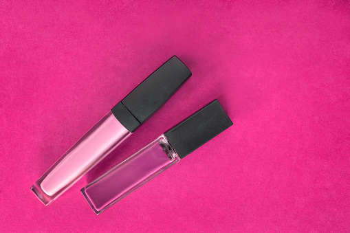Two lip gloss packs on fuchsia color background