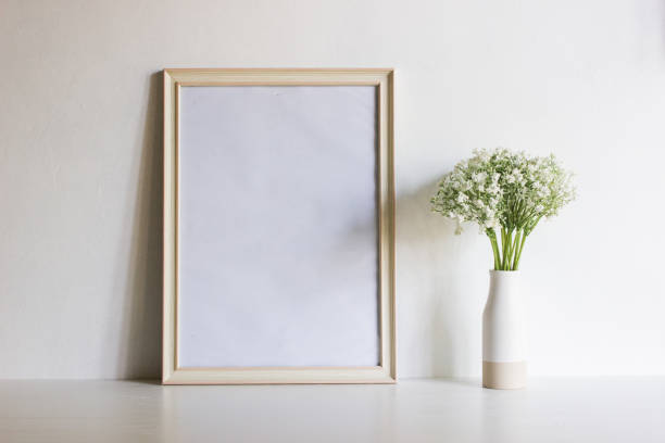 istock Green leaves with white wooden frame on table with natural light. 1417865208