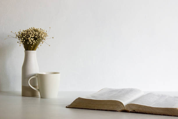 istock Holy Bible with flower in a vase with coffee cup over the white table. 1417865438