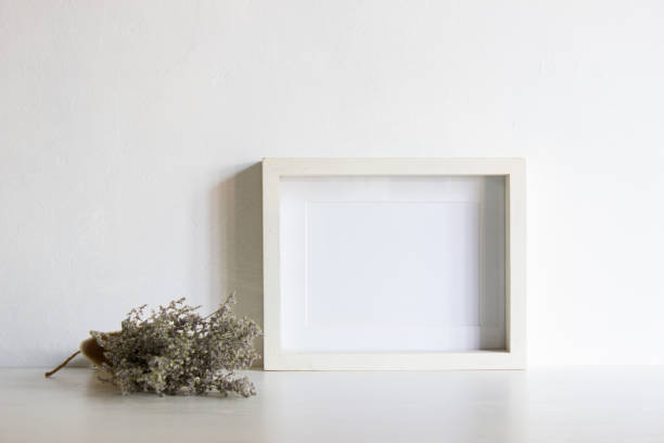 istock White flowers with white frame over the table with natural light. 1417865474