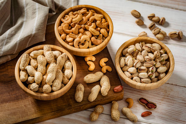 istock Three bowls filled with peanuts, cashew and pistachio shot from above 1417865646