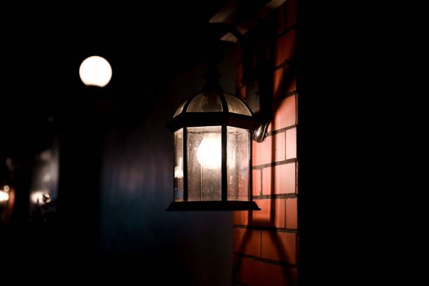 istock Closeup shot of a lamp fixed on a stone wall in darkness 1417870680
