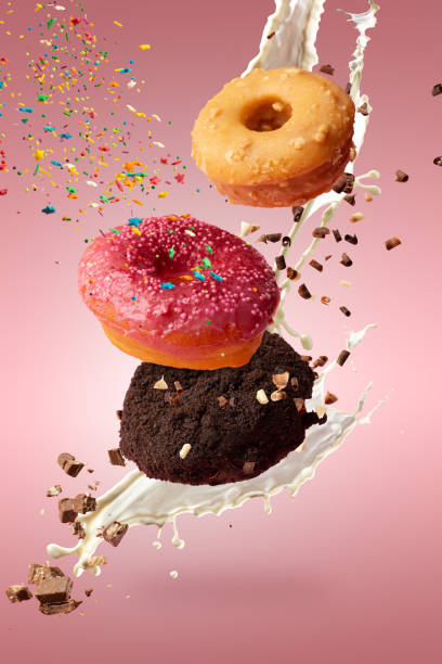 istock Three sweet donuts levitate with powder, chocolate and milk. 1417870732