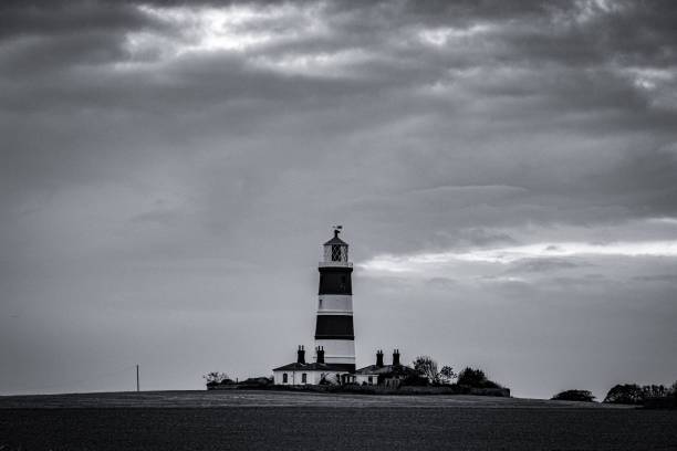 istock Grayscale shot of a lighthouse on the cloudy sky background 1417875529