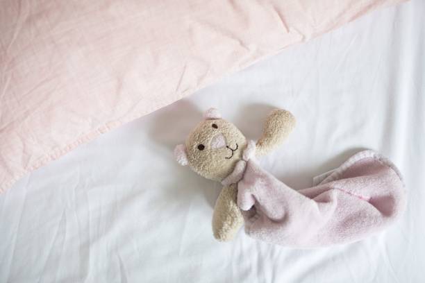 istock Top view of a small teddy bear on bed 1417879103