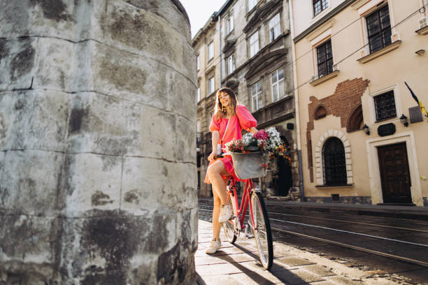 The cheerful  beautiful woman come to work by her vintage bicycle in the morning