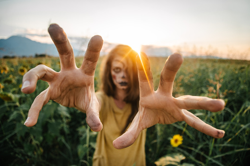 Disguised woman for Halloween approaching with hands