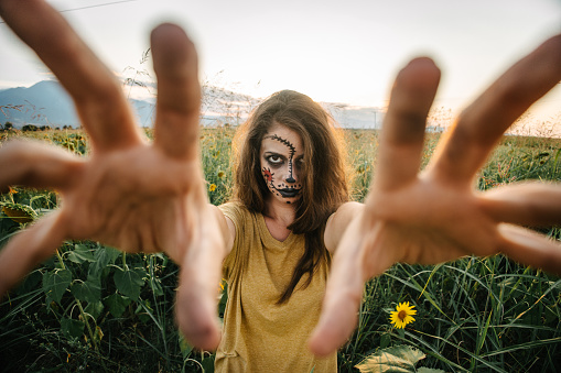 Disguised woman for Halloween approaching with hands