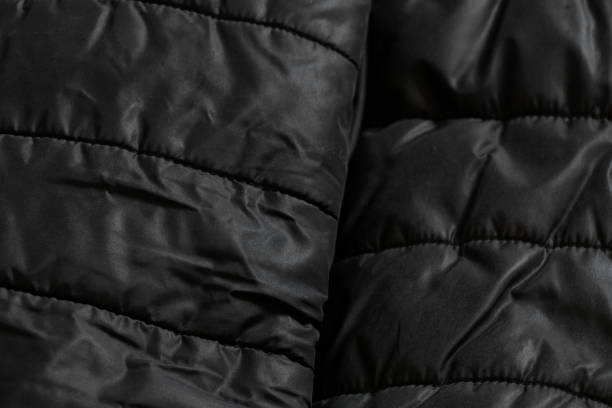 istock women's padded black padded jacket as background, soft black fabric 1417882782