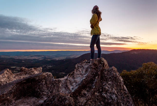 istock Woman looking out over mountains as sun sets 1417883992