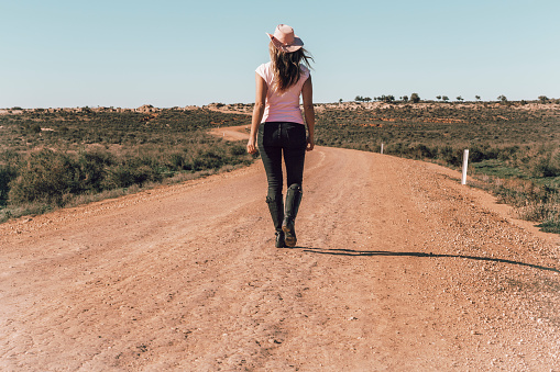 Woman walking dusty roads of outback Australia
