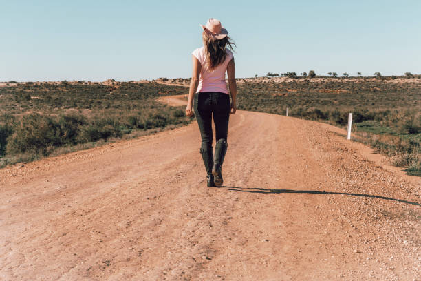 Woman walking dusty roads of outback Australia stock photo