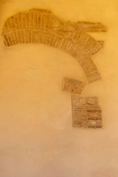 background masonry is exposed in a stucco wall