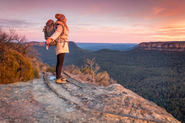 istock Female hiker feeling  warm sunlight hit her face on a cold chilly winter day 1417884117