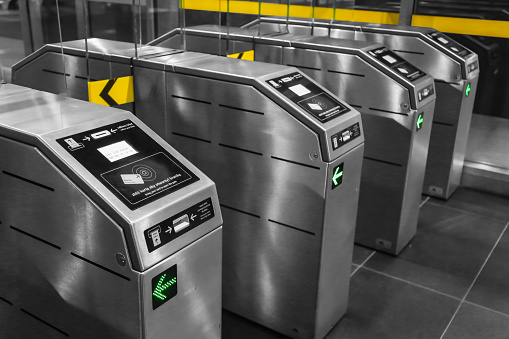 View on metro station ticket barriers with green light for entry. European metro station. Station entrance tourniquet green light to enter to run. New modern metro ticket barriers metal construction