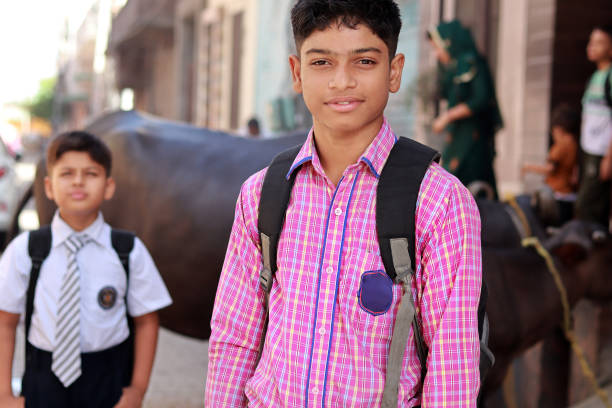 Close-up portrait of high school student standing against rural background, Panipat, Haryana, India.