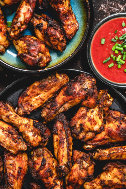 istock Grilled chicken wings on a black plate on a dark rustic background 1417890235