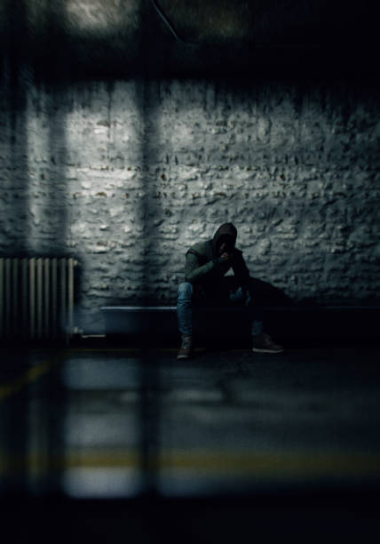 Sad man sitting alone in the dark room.
