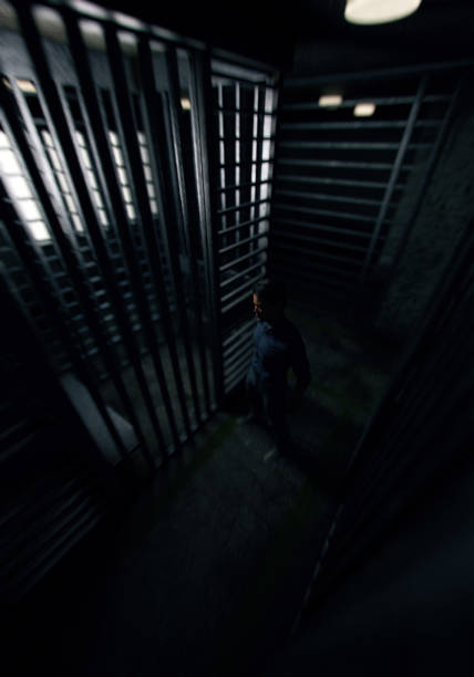 istock Prisoner in front of his cell in dark cell block. 3D render. 1417890681