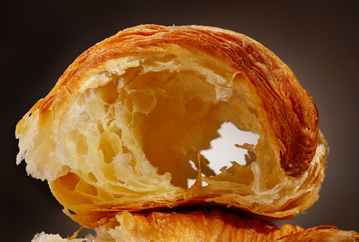 Detail of flesh or pulp of the tasty croissant, close up. French pastry. Hole in the bun. Shallow depth of field.