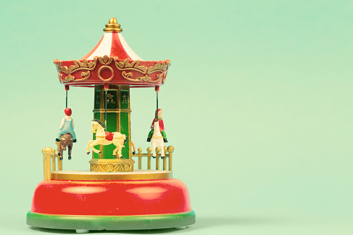 Vintage toy carousel on an emerald background. Red carillon with carousel, retro carousel