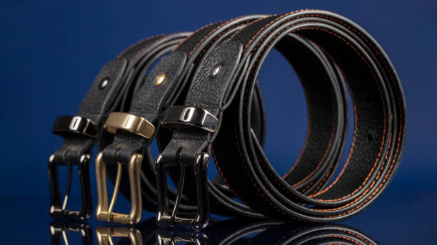 istock Group of black leather belts on a blue background. 1417892163