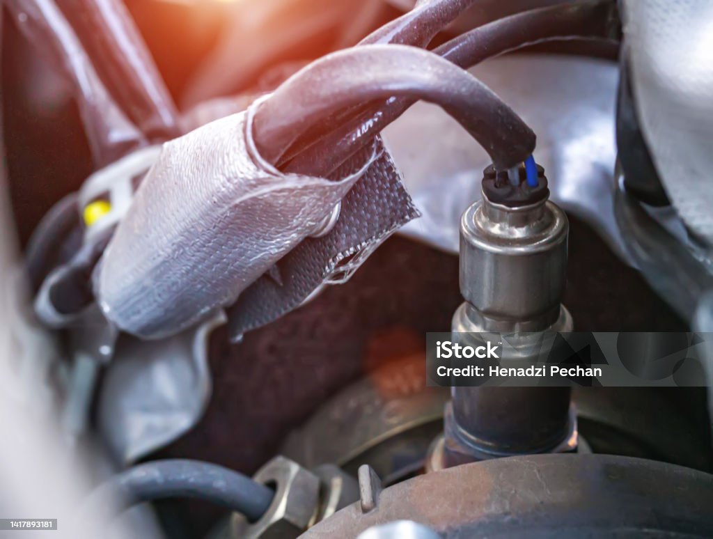Automotive sensor lambda probe in a diesel engine. Measuring oxygen content in car exhaust gases, macro Automotive sensor lambda probe in a diesel engine. Measuring oxygen content in car exhaust gases Backgrounds Stock Photo