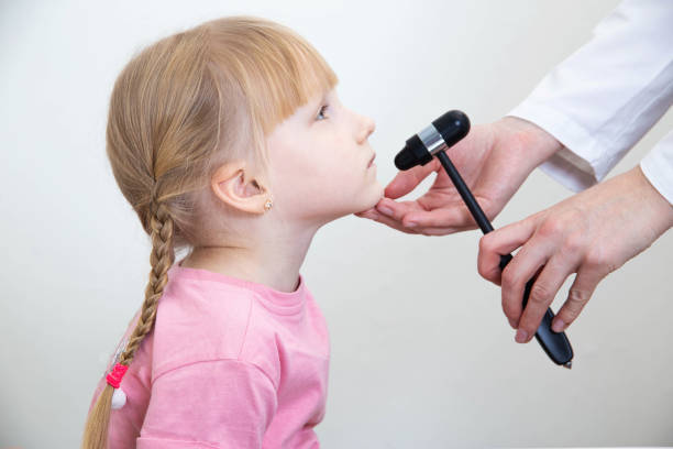 um neuropatologista verifica o reflexo mandibular em uma menina de 5 anos. close-up, exame neurologista - neuropathologist - fotografias e filmes do acervo