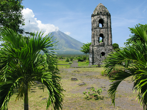 View of church tower of the Cagsawa Church, which was destroyed by the 1814 eruption of Mayon Volcano in background, Legaspi City, Luzon Island, Philippines.