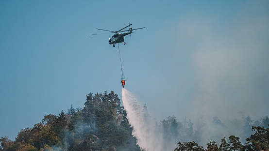 Firefighter helicopter and fire in the forest.