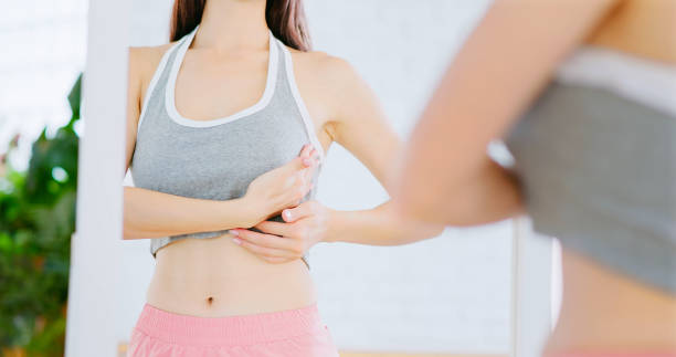 girl touching her chest close up asian girl touching her chest in front of mirror at home self test stock pictures, royalty-free photos & images