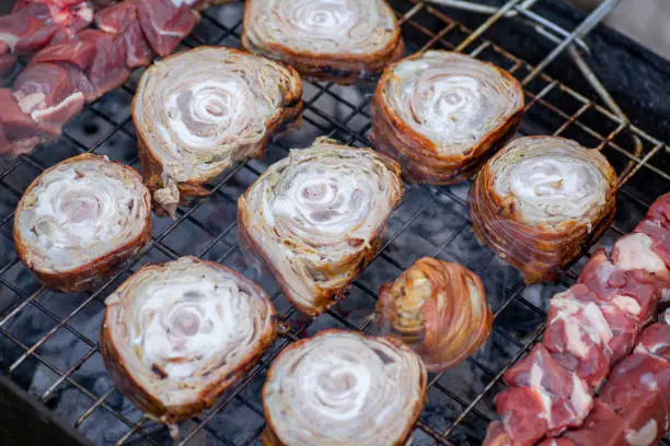 View of a kokorec and chopped meat on grill.

Kokorec is a dish of the Balkans and Asia Minor, consisting of lamb or goat intestines wrapped around seasoned offal, including sweetbreads, hearts, lungs, or kidneys, and typically grilled; a variant consists of chopped innards cooked on a griddle. The intestines of suckling lambs are preferred.