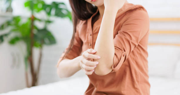 girl itching arm close up asian girl suffering from itchiness of her arm in winter at home skin scrape stock pictures, royalty-free photos & images