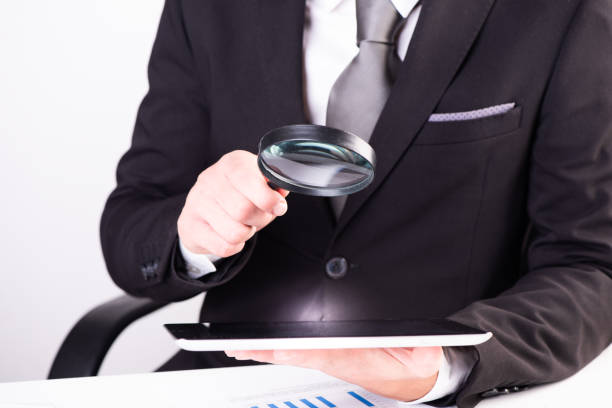 istock Auditor holding magnifying glass and tablet 1417899469