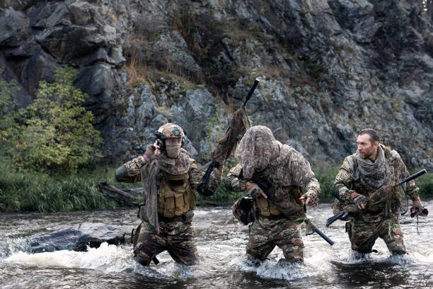 istock Mercenary soldiers ford a river during a special operation. 1417899471
