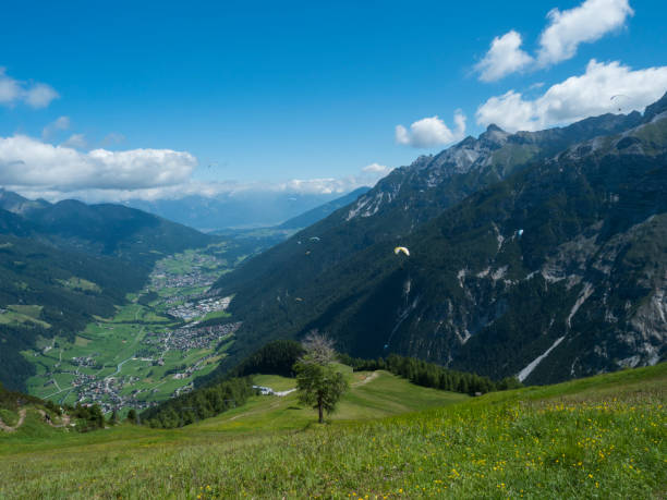 View over green Stubai valley and Neustift im Stubaital village from Elferhutte with moutain peaks and kites. Tirol Alps, Austria, Summer blue sky, white clouds View over green Stubai valley and Neustift im Stubaital village from Elferhutte with moutain peaks and kites. Tirol Alps, Austria, Summer blue sky, white clouds. neustift im stubaital stock pictures, royalty-free photos & images