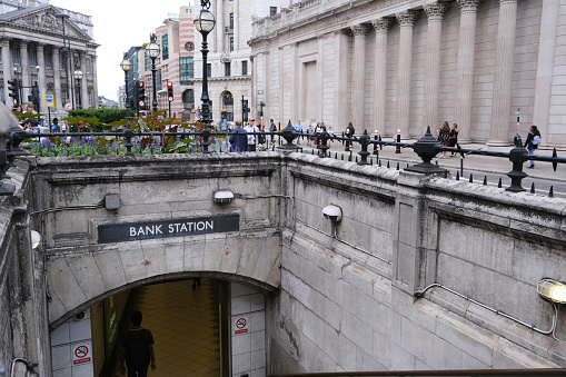 Bank tube or underground station entrance with signage and Threadneedle street and the Bank of England to the left. City of London, United Kingdom, August 22, 2022.
