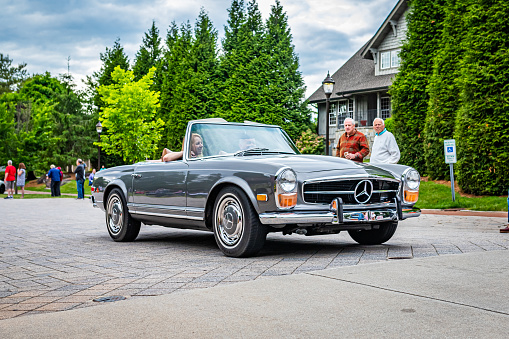 Highlands, NC - June 10, 2022: Low perspective front corner view of a 1969 Mercedes Benz 280 SL Convertible Coupe leaving a local car show.