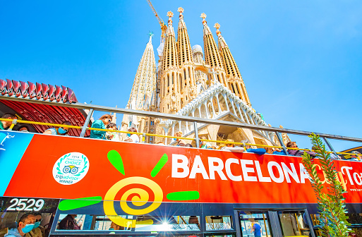 Barcelona, Spain - 20 April, 2022: Famous Basilica de la Sagrada Familia and Barcelona city tour bus, Spain travel photo