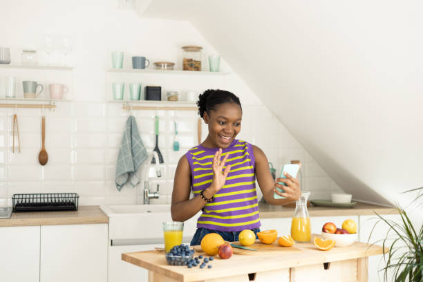 istock Happy African young woman making a video call while making fresh juice 1417910372