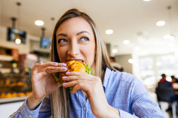 istock Young women eating sandwich looking through window 1417911438
