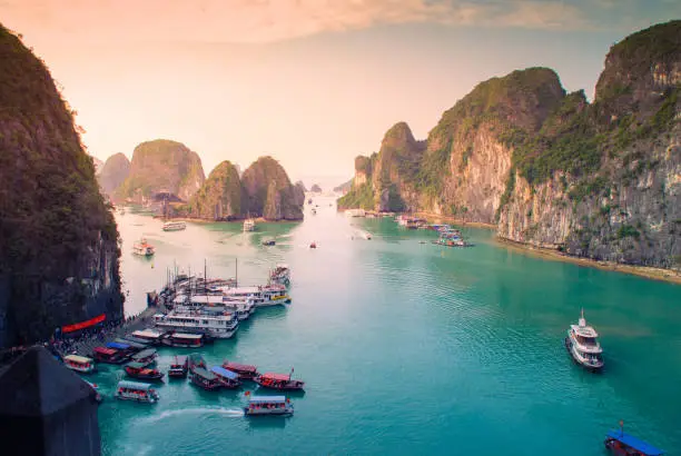 Photo of Aerial view of sunset and dawn near rock island, Halong Bay, Vietnam, Southeast Asia. UNESCO World Heritage Site. Junk boat cruise to Ha Long Bay.