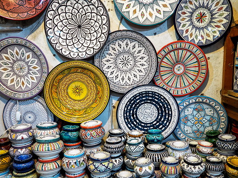 Handmade colourful decorated bowls or cups on display at traditional souk - street market in Morocco