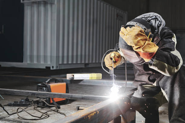 istock Welder in protective mask welds steel constructions. 1417914478