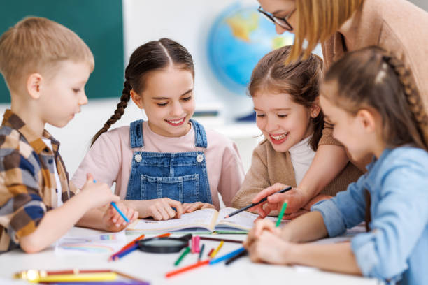 istock Teacher helping children with schoolwork 1417915000